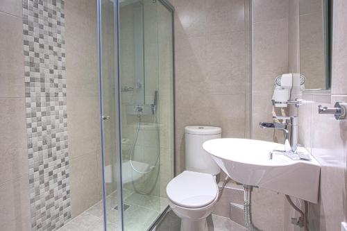 La salle de bains est pourvue de toilettes et d'une douche en verre. dans l'établissement Emilia Hotel Apartments, à Réthymnon