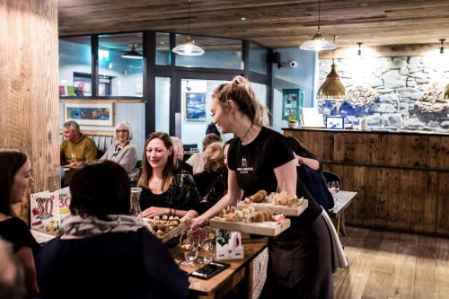 a woman holding a tray of food in a restaurant at Harbourmaster Hotel in Aberaeron