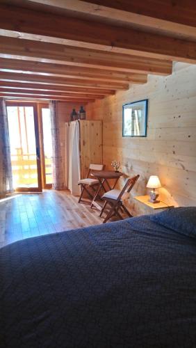 una habitación con mesa y sillas en una cabaña en Les marmottes d Estenc, en Estenc