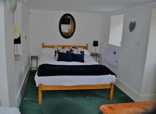 a bedroom with a large bed with blue pillows at Airds Farm Guest House in Castle Douglas