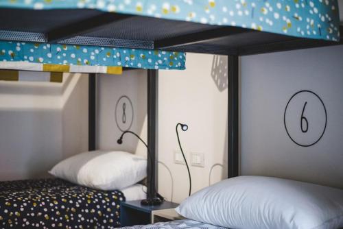 a room with two beds and a bunk bed at The Hostello in Verona