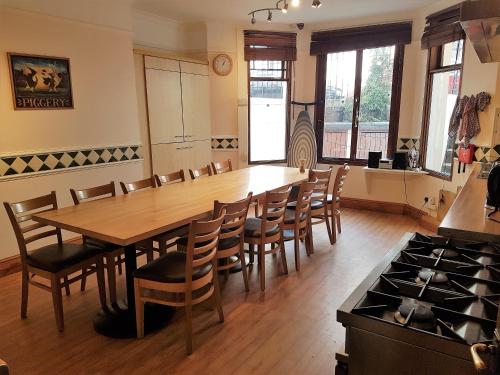 a dining room with a large wooden table and chairs at Barmy Badger Backpackers in London