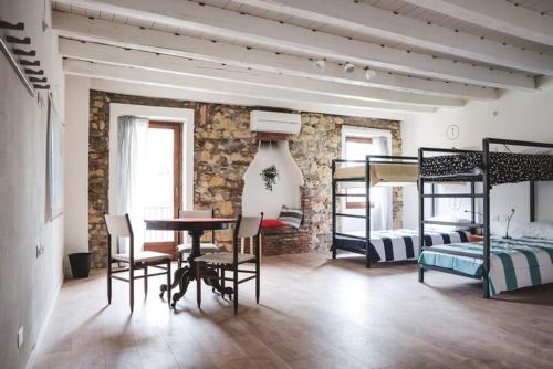 a room with a table and chairs and bunk beds at The Hostello in Verona
