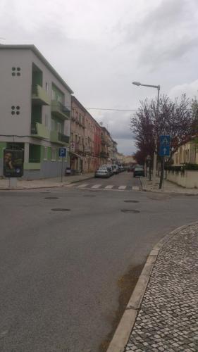 an empty street with cars parked on the side of the road at Casa do Jardim Escola in Tomar