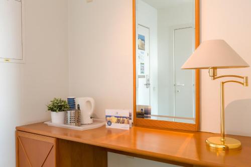 a desk with a lamp and a mirror on it at Seaside Blankenberge in Blankenberge