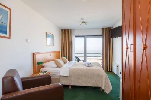 um quarto de hotel com uma cama e uma varanda em Seaside Blankenberge em Blankenberge