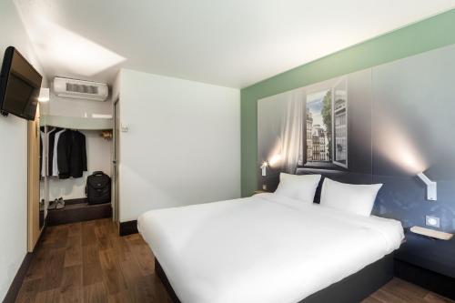 コルベイユ・エソンヌにあるB&B HOTEL Corbeil-Essonnesのベッドルーム(大きな白いベッド1台、クローゼット付)