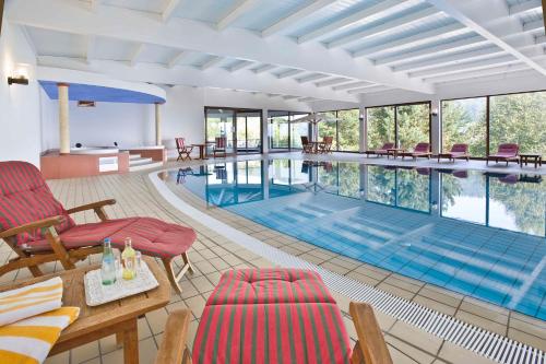 a large swimming pool with chairs and a table at Eden au Lac in Echternach