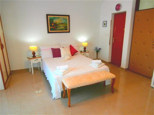 ein Schlafzimmer mit einem Bett mit zwei Tischen und zwei Lampen in der Unterkunft Apartments Song in Split