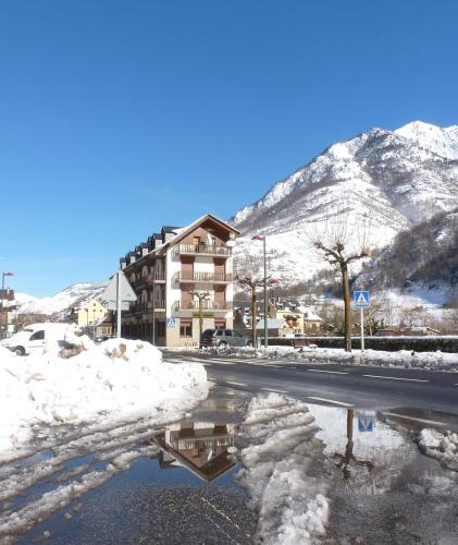 a reflection of a building in a puddle in the snow at Hotel Garona in Bossost