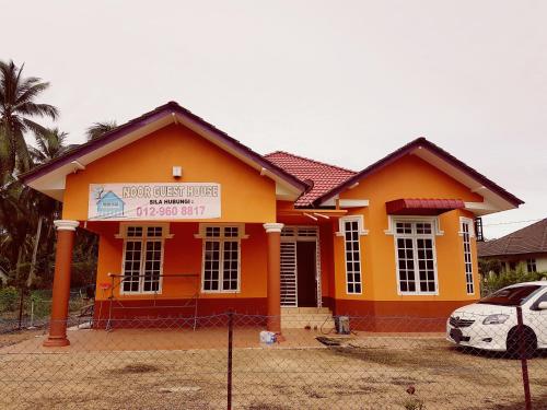 a house with a sign in front of it at Noor Guesthouse in Kampong Alor Ganu