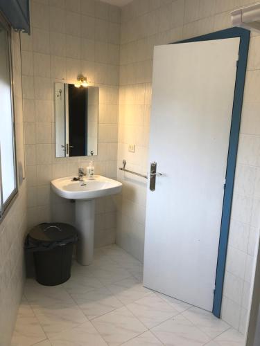 a bathroom with a sink and a mirror and a door at A Senda in Caldas de Reis