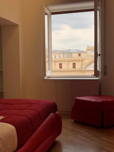 una camera da letto con una grande finestra con vista su un edificio di Maison Arena Bovio a Napoli