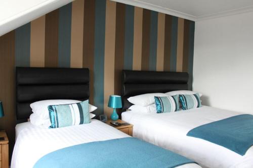 two beds sitting next to each other in a bedroom at Rosebank Guest House in Perth