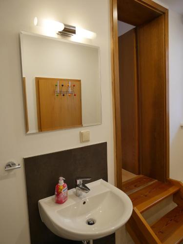 a bathroom with a white sink and a mirror at Ferienhaus Caspar David Friedrich in Lohme