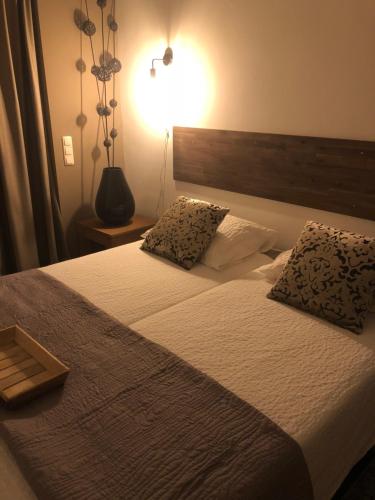 a bedroom with a bed with two pillows on it at Fietshotel Le Baroudeur in Valkenburg