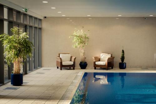 a hotel lobby with a swimming pool and chairs at Rochestown Lodge Hotel in Dun Laoghaire