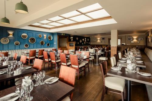 uma sala de jantar com mesas e cadeiras num restaurante em Rochestown Lodge Hotel em Dún Laoghaire