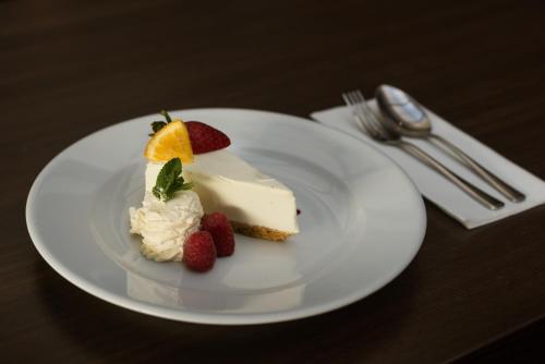 a piece of cake and strawberries on a white plate at Rochestown Lodge Hotel in Dun Laoghaire