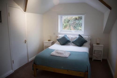 a small bedroom with a bed with a window at The Haven in Portreath