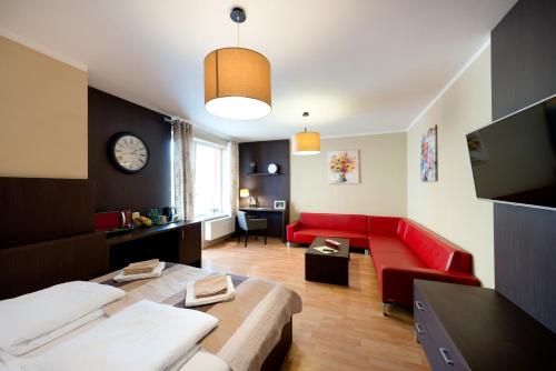 a living room with a red couch and a clock at B2B Apartments in Jihlava