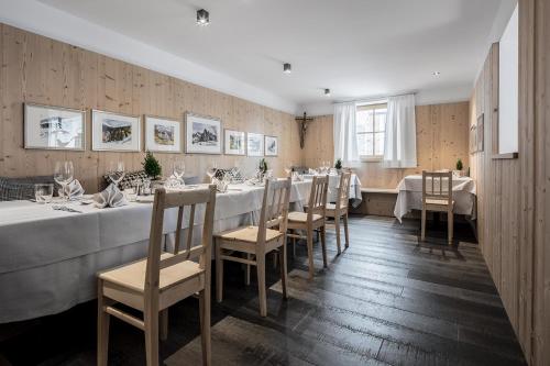 een eetkamer met een lange tafel en stoelen bij Hotel Conturines in San Cassiano