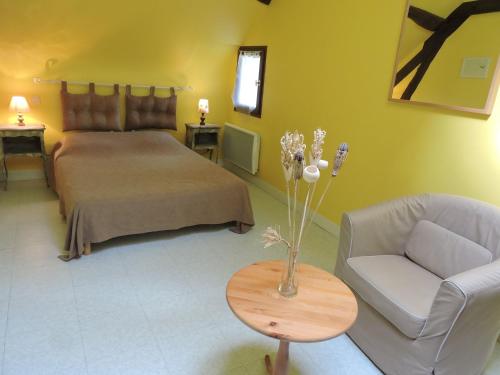 1 dormitorio con cama, sofá y mesa en Les Pres Verts, en Mareuil-sur-Cher