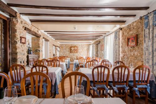 un restaurante con mesas y sillas en una sala con paredes de piedra. en Casa Banys L'Avellà, en L’Avellà