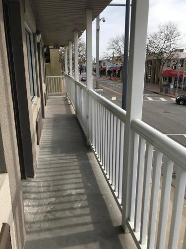 a porch of a building with white railing and a street at Ocean's 24 in Virginia Beach