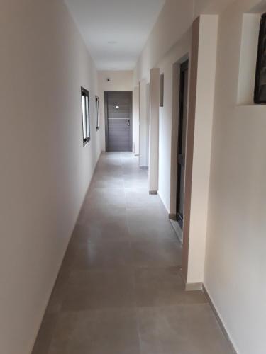 an empty hallway with white walls and a long corridor at The Santo George Beach Resort in Amoudara Herakliou