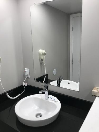 a white sink in a bathroom with a mirror at Ocean's 24 in Virginia Beach