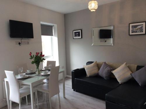 a living room with a black couch and a table at Rooftop Apartments in Belfast