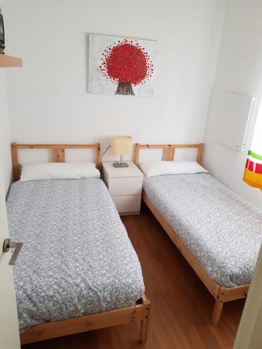 two beds in a room with white walls and wooden floors at Domus Valencia Apartamentos Casa con piscina privada a 30 minutos de Valencia in Turís