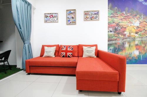 a red couch in a living room with some pillows at H2H - Swiss Home - Majestic Ipoh in Ipoh