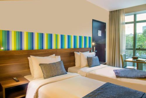 a hotel room with two beds and a colorful wall at Prodigy Santos Dumont by Wish in Rio de Janeiro