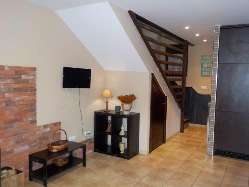 a living room with a staircase and a tv at Las Cabraliegas in Arenas de Cabrales