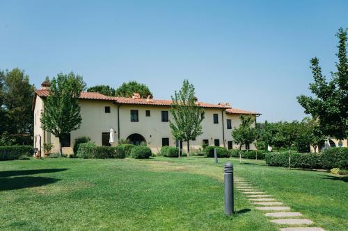 una casa grande con césped delante en Gatto Bianco Tizzauli en Montespertoli