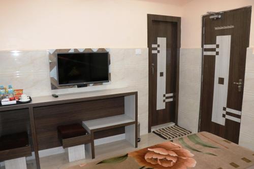 a living room with a tv and a fireplace at Hotel Prince B in Guwahati