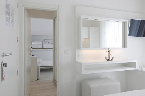 un bagno bianco con lavandino e specchio di Hotel Gambrinus Mare a Cattolica