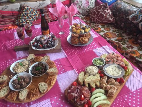 a table topped with lots of food and a bottle of wine at The Pink House in Polkownik Serafinowo
