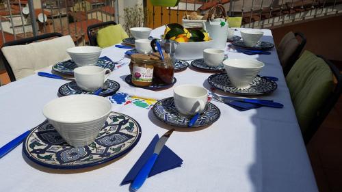 a table with blue and white cups and plates on it at Casa Verde Sardinia in Cuglieri