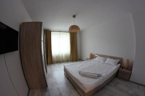 sypialnia z białym łóżkiem i oknem w obiekcie Apartament Centru Istoric Radu w Sybinie