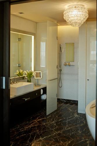 a bathroom with a sink and a tub and a mirror at Park Hyatt Hotel and Residences, Hyderabad in Hyderabad