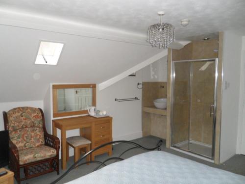1 dormitorio con silla, escritorio y espejo en Big Sky Guest House- ROOM ONLY, en Whitby