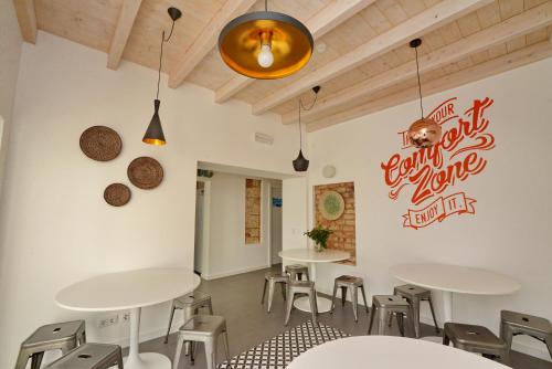 a restaurant with tables and chairs and a sign on the wall at Son of a Beach Hostel in Albufeira