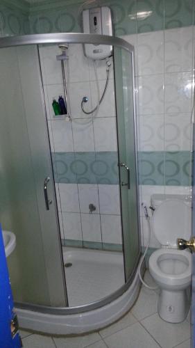 a bathroom with a glass shower with a toilet at Kokomos Hotel and Restaurant in Angeles