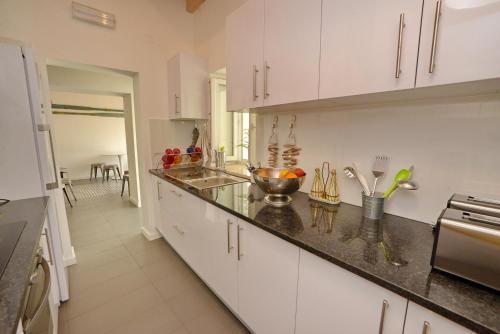 a kitchen with white cabinets and a counter top at Son of a Beach Hostel in Albufeira