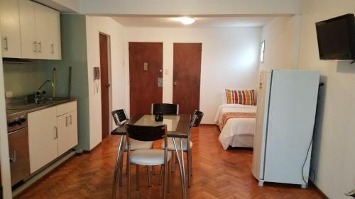 a kitchen with a table and chairs in a room at Temporarios Peatonal in Rosario