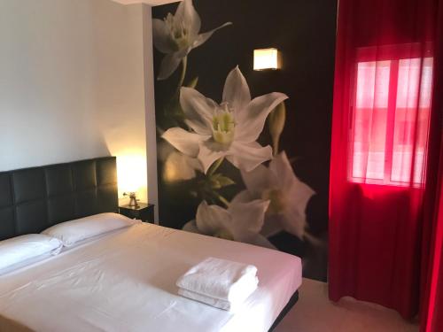 a bedroom with a bed with a flower mural on the wall at Saval Spa Aqquaria Family Complex in Salou