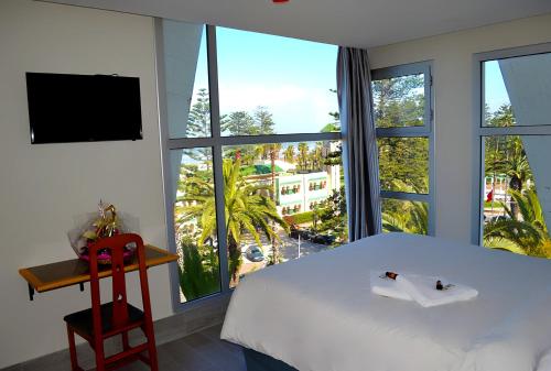 傑迪代的住宿－Hotel Centre Ville，卧室设有白色的床和大窗户